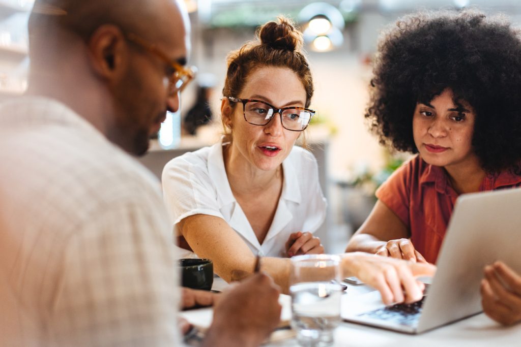 Communications leaders reviewing AI output on a laptop